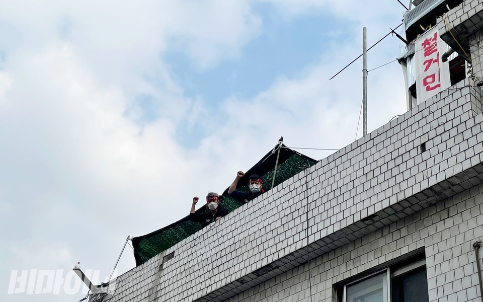 성일장 여관 건물 옥상에 고립돼 있는 철거민들이 ‘투쟁’을 외치고 있다. 왼쪽이 이해옥 씨. 사진 하민지