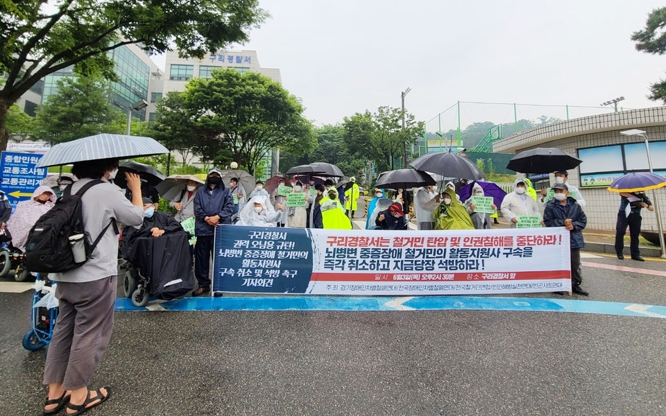 시민사회단체 활동가들은 구리경찰서 앞에서 활동지원사 이 씨의 석방을 촉구하는 기자회견을 열었다. 비가 와서 우산을 쓰거나 우의를 입은 모습. 사진 노들장애인야학