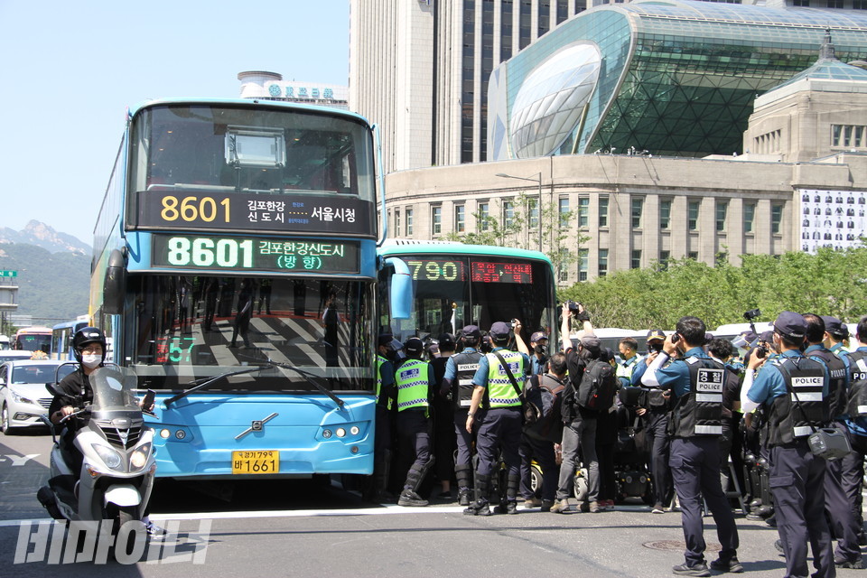 서울시청 도로 앞에서 장애인들이 장애인은 탈 수 없는 버스를 막아세우자 경찰들이 달려가고 있다. 사진 이가연