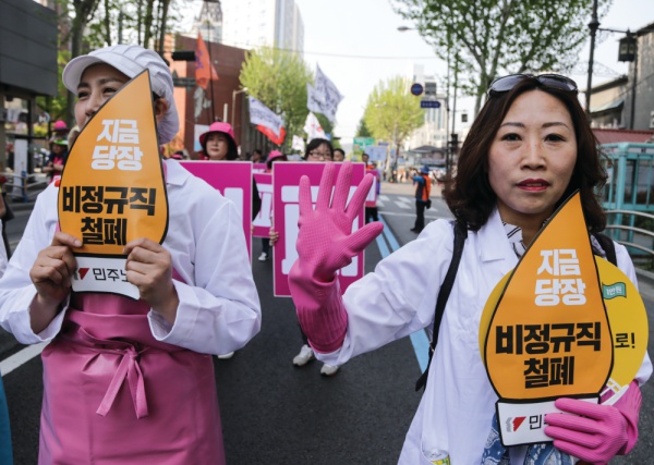 여성노동자들이 “지금 당장 비정규직 철폐”라고 적힌 손피켓을 들고 행진하고 있다. 사진 참세상