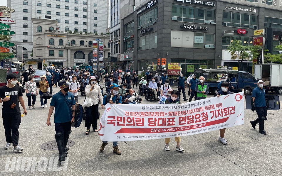 국민의힘 당사 앞에서 기자회견을 마친 활동가들이 민주당 당사를 향해 행진하고 있다. 사진 하민지