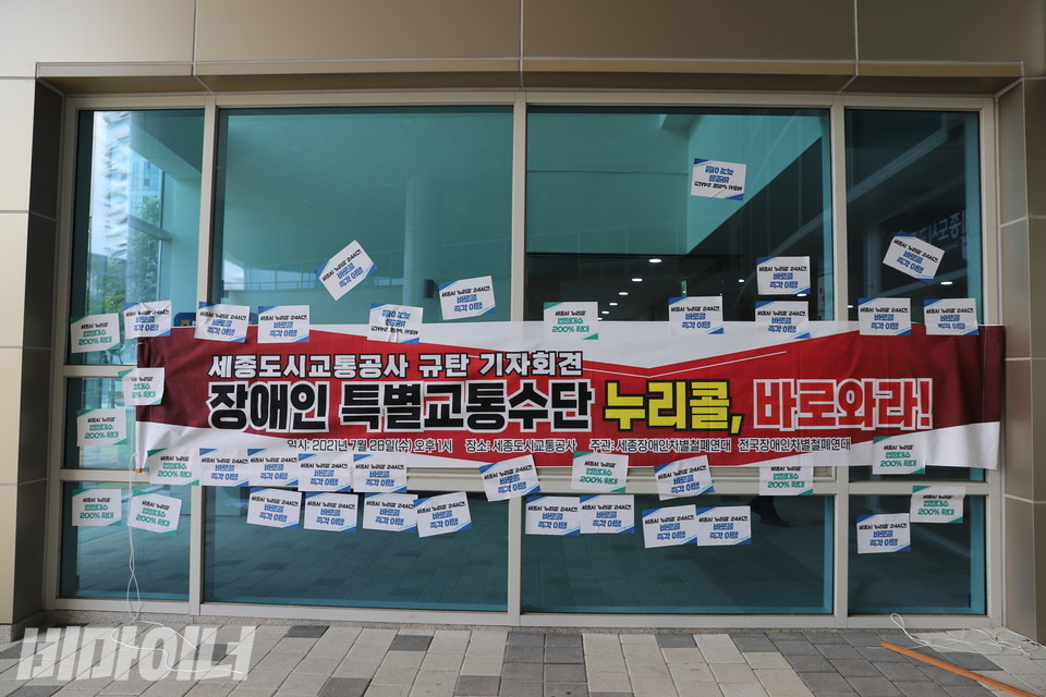 활동가들은 기자회견이 끝난 후 공사 건물 외벽에 현수막과 피켓을 붙였다. 빨간색 현수막에는 ‘세종도시교통공사 규탄 기자회견, 장애인 특별교통수단 누리콜 바로 와라’라고 적혀 있다. 사진 하민지