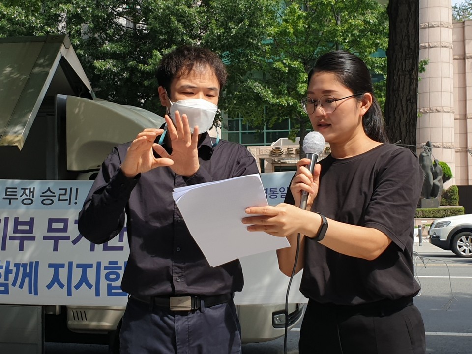 수어로 발언하는 정동환 수어통역사(왼쪽). 사진 차별상담네트워크