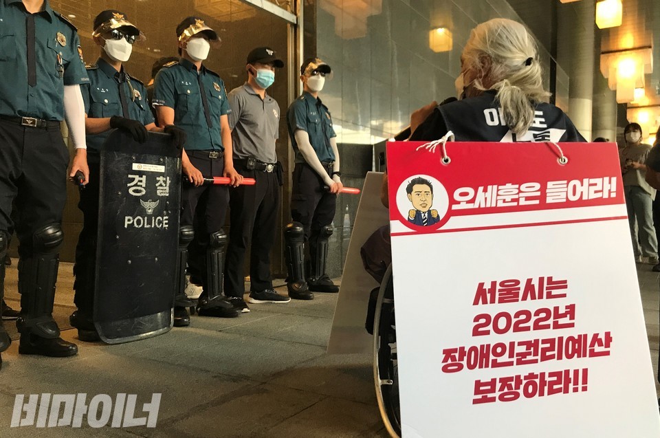 장애인 활동가들이 행진 도중 후문에 멈춰서 오세훈 서울시장, 복지정책실장, 기획조정실장의 면담을 촉구하고 있다. 사진 허현덕