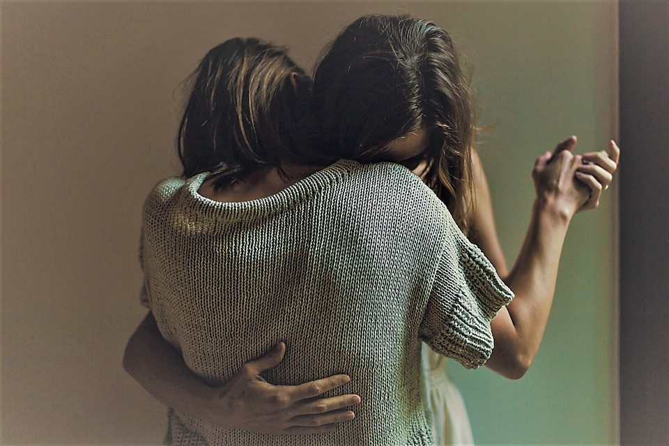 두 사람이 자신의 얼굴을 서로의 어깨에 기댄 채 춤을 추고 있다. 한 손은 서로를 맞잡고 있으며 다른 한 손은 서로의 등을 감싸듯 안고 있다. 사진 언스플래쉬