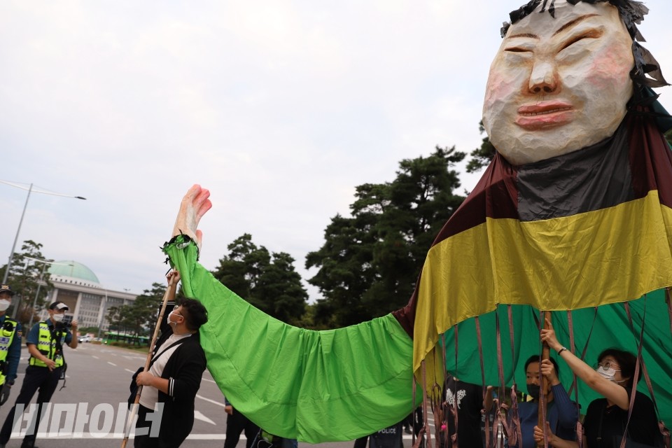 15일, 오후 4시 경기장차연 등이 민주당 당사 앞을 찾아가 규탄 퍼포먼스를 벌였다. 기자회견 참여자들이 발달장애인을 형상화 한 커다란 조형물을 들고 국회 앞을 행진하고 있다. 사진 이가연