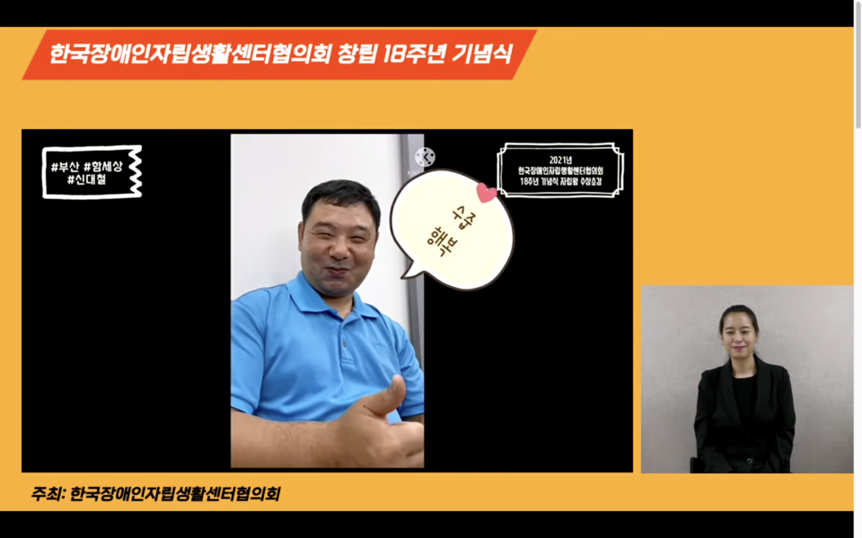 신대철 활동가가 영상으로 수상소감을 전하며 '최고'의 의미로 엄지손가락을 치켜세워 보이고 있다. 환하게 웃고 있다. 신 활동가 오른쪽에는 '수줍', '행복'이라 적힌 말풍선이 그려져 있다. 사진 한자협 유튜브 캡처