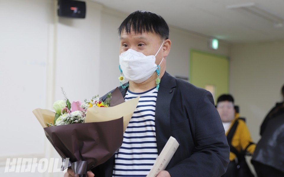 프리웰 지원주택에 사는 이하용 씨가 57명을 대표해 상을 받고 있다. 이 씨의 손에 꽃다발이 들려 있다. 사진 하민지