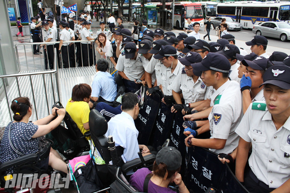 2012년 8월 12일, 광화문역에 도착한 장애인 활동가들이 경찰 방패에 막히자 이에 항의하며 싸우고 있다. 사진 비마이너DB