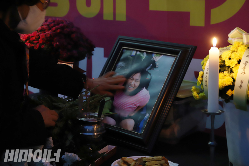 고 김주영 활동가의 어머니가 딸의 영정사진을 손으로 쓰다듬고 있다. 사진 강혜민