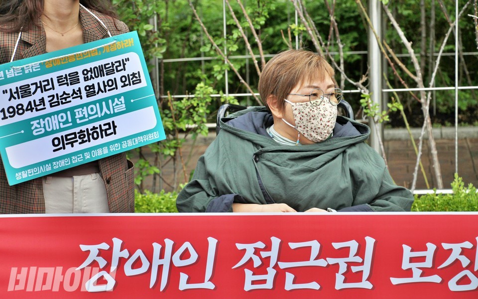 장애인차별금지추진연대 등은 지난 4월 13일, ‘장애인등편의법이 헌법에 위배된다’는 위헌법률심판 제청을 알리는 기자회견을 열었다. 이 법에 따르면 300㎡(약 90평) 이하인 건물은 장애인 편의시설을 설치하지 않아도 된다. 당시 기자회견에 참여한 박김영희 대표. 박김영희 대표 앞에는 ‘장애인 접근권 보장’이라고 적힌 현수막이 펼쳐져 있고, 왼쪽에는 한 활동가가 ‘“서울거리 턱을 없애달라” 1984년 김순석 열사의 외침, 장애인 편의시설 의무화하라’라고 적힌 피켓을 들고 있다. 사진 하민지