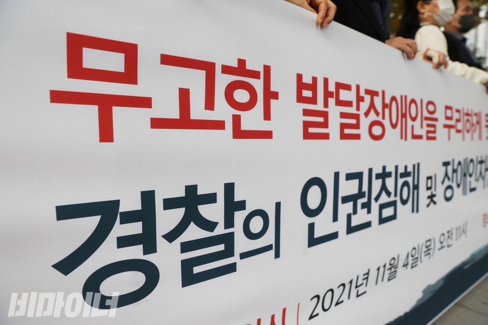 기자회견 현수막. 빨간 글씨로 ‘무고한 발달장애인’, 남색 글씨로 ‘경찰의 인권침해’라고 적혀 있다. 사진 하민지