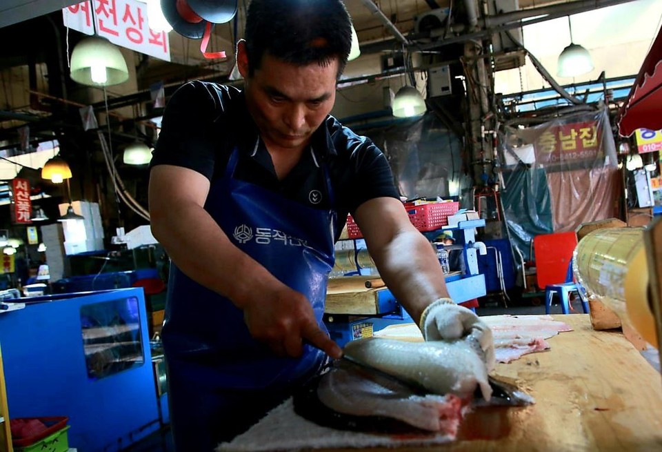 나세균 씨가 생선을 손질하고 있다. 나 씨 뒤로 ‘여천상회’라고 적힌 간판이 보인다. 사진 최인기