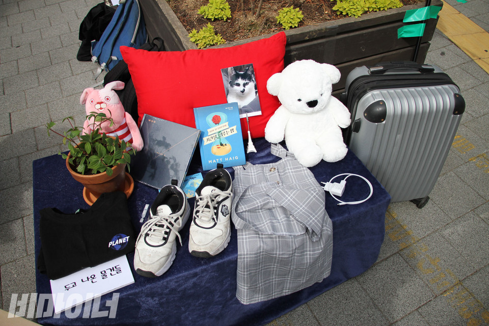 지난 4월 2월, 서울시 보궐선거를 맞아 청소년주거권네트워크는 차기 서울시장에게 아동·청소년 주거권 보장을 위한 정책을 요구하는 기자회견을 열었다. 당시 기자회견에서 퍼포먼스로 ‘가정 밖으로 나올 때 두고 온 물건들’을 전시한 풍경. 작은 테이블 위엔 화분, 인형, 고양이, 운동화, 티셔츠, 치마 등이 놓여 있고, 그 옆으로 캐리어 한 개가 있다. 사진 강혜민