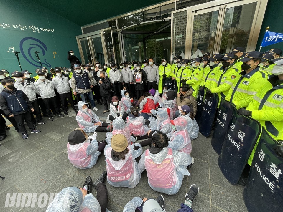 시청 정문을 막은 수십 명의 경찰. 상인들이 바닥에 주저 앉아 있다. 한 가운데에 나세균 열사의 영정이 있다. 사진 하민지