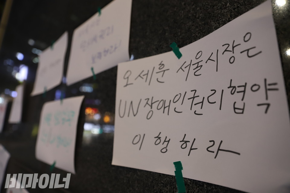 시청 후문 외벽에 붙은 피켓. ‘오세훈 서울시장은 UN장애인권리협약 이행하라’라고 적혀 있다.