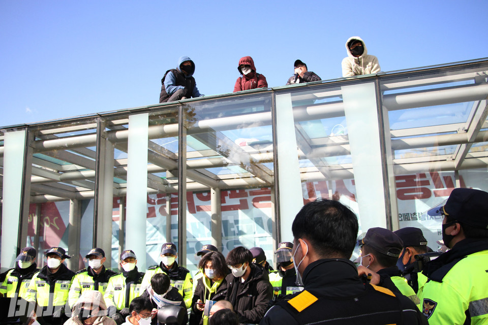 장애인 활동가들이 12일 오전 11시 30분, 국회의사당역 1번 출구 유리지붕에 올랐다. 사진 강혜민