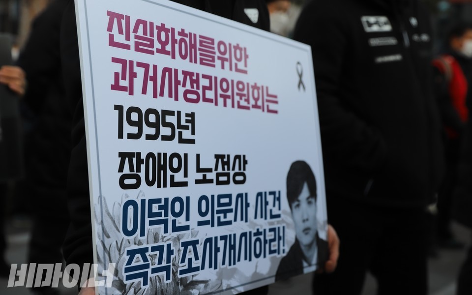 ‘진실화해를위한과거사정리위원회는 1995년 장애인노점상 이덕인 의문사 사건 즉각 조사개시하라!’라고 적힌 피켓. 사진 하민지