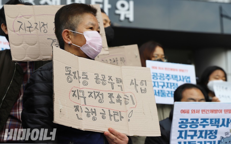 동자동 주민이 ‘동자동 공공주택 사업 지구지정 조속히 진행하라!’라고 적힌 피켓을 들고 있다. 사진 하민지