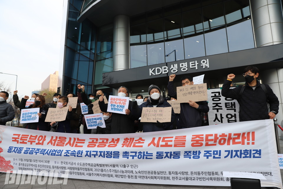 LH가 있는 KDB생명타워 앞 기자회견 현장. 동자동 쪽방 주민들이 피켓을 들고 ‘투쟁’을 외치고 있다. 현수막에는 ‘국토부와 서울시는 공공성 훼손 시도를 중단하라!! 동자동 공공주택사업의 조속한 지구지정을 촉구하는 동자동 쪽방 주민 기자회견’이라 적혀 있다. 사진 하민지