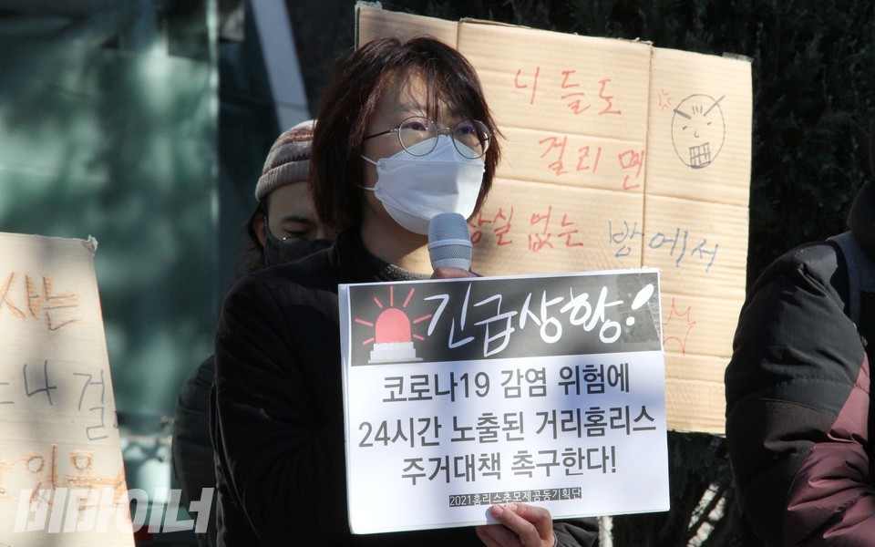 이보라 공동대표가 ‘긴급상황! 코로나19 감염 위험에 24시간 노출된 거리홈리스 주거대책 촉구한다!’라고 적힌 피켓을 들고 발언하고 있다. 사진 하민지