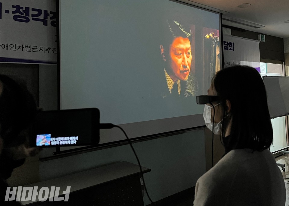 장애우권익문제연구소 등 장애인권단체가 2일 폐쇄형 배리어프리 영화상영 시연회를 열었다. 한 참가자가 스마트 안경을 쓰고 영화해설과 대사를 보고 있다. 사진 허현덕