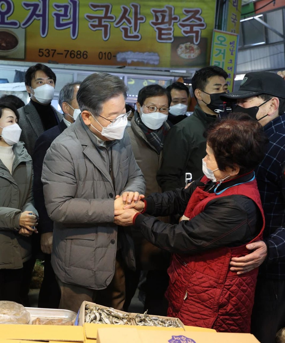 이재명 더불어민주당 대통령 후보가 시장에서 상인과 손을 잡고 있다. 사진출처 이재명 페이스북