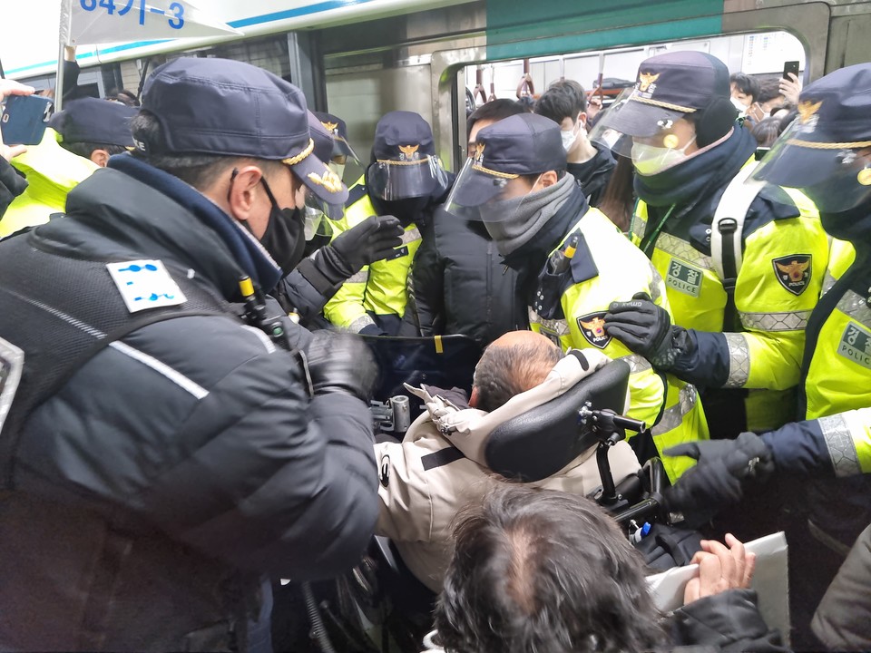 경찰들이 지하철 앞에서 선전전을 하는 이규식 상임공동대표를 둘러싸 막고 있다. 사진 제공 전장연
