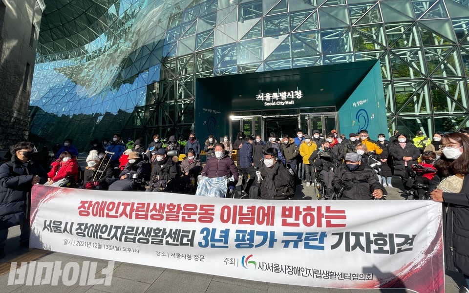 서울시청 앞 기자회견 현장. 현수막에 ‘장애인자립생활운동 이념에 반하는 서울시 장애인자립생활센터 3년 평가 규탄 기자회견’이라 적혀 있다. 현수막 뒤로 활동가 30여 명이 집결해 있다. 사진 하민지