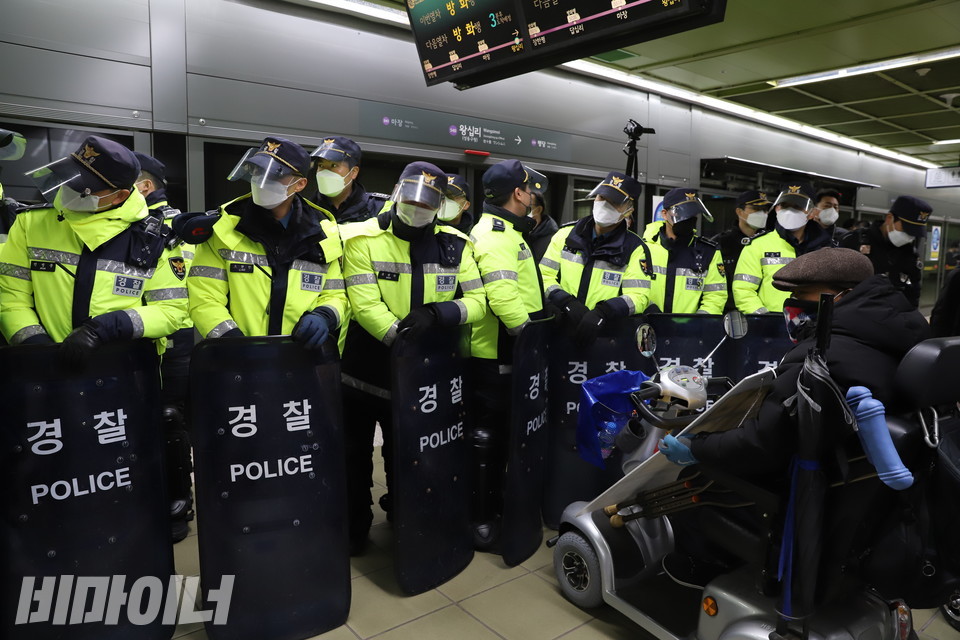 20일 오전 7시경 왕십리역. 경찰 수십 명이 방패로 무장하고 휠체어 이용 장애인이 지하철을 타지 못하게 막아서고 있다. 사진 하민지