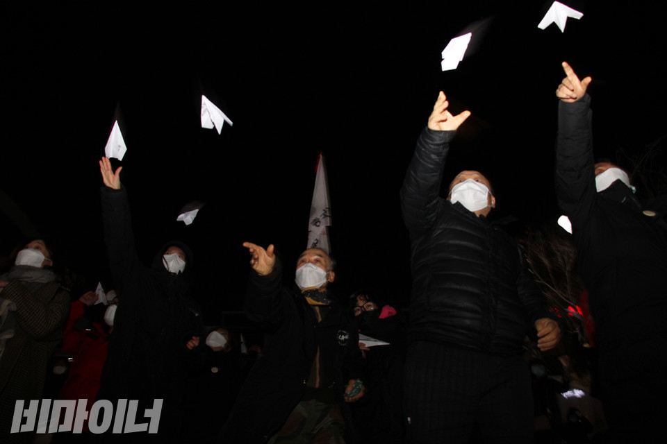 홈리스추모문화제 참가자들이 권리선언문이 적힌 에이포 종이를 종이비행기로 접어 날리고 있다. 사진 강혜민