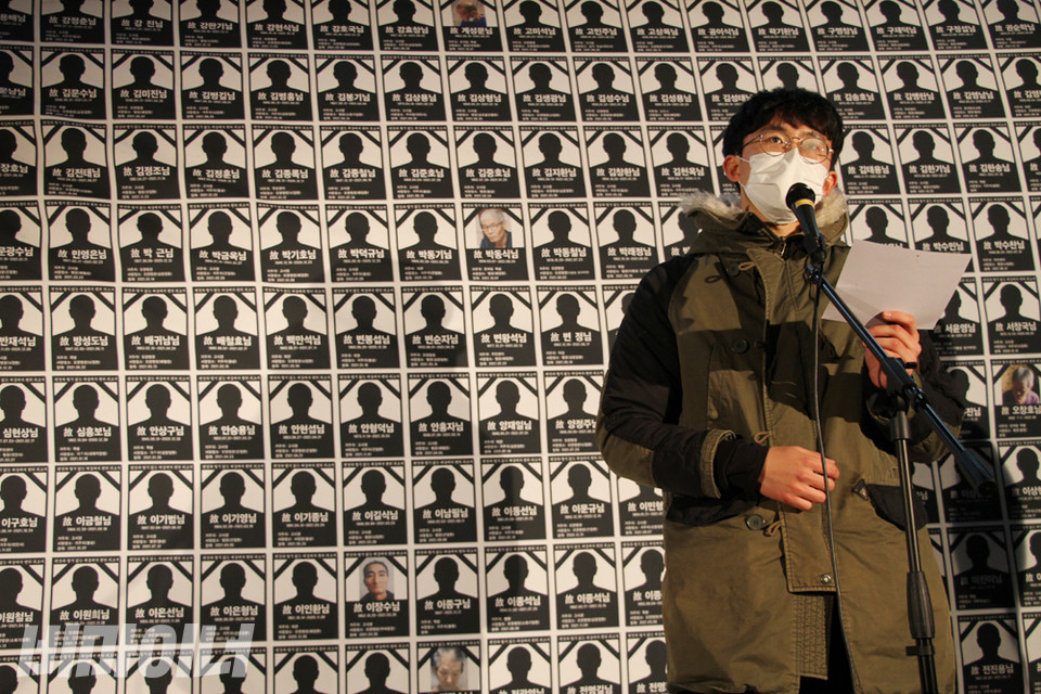 주장욱 아랫마을 홈리스야학 교사가 추모문화제 사회를 보고 있다. 그의 뒤로 395명의 영정이 넓게 펼쳐져 있다. 사진 강혜민