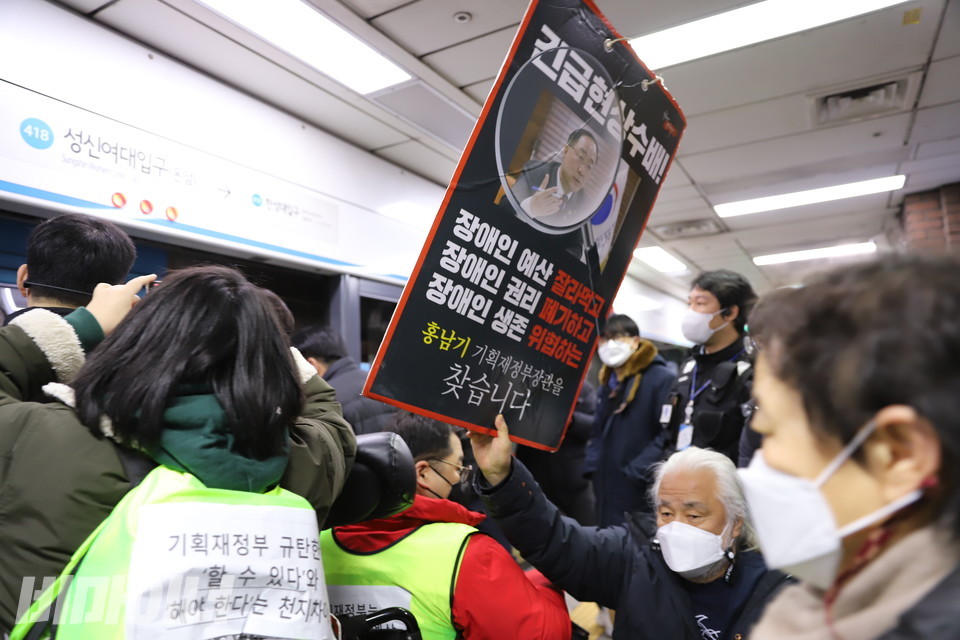 박경석 전국장애인야학협의회 이사장은 2년 전 목에 걸고 투쟁했던, '긴급현상수배 홍남기 기획재정부장관을 찾습니다' 피켓을 들어보이고 있다. 사진 허현덕