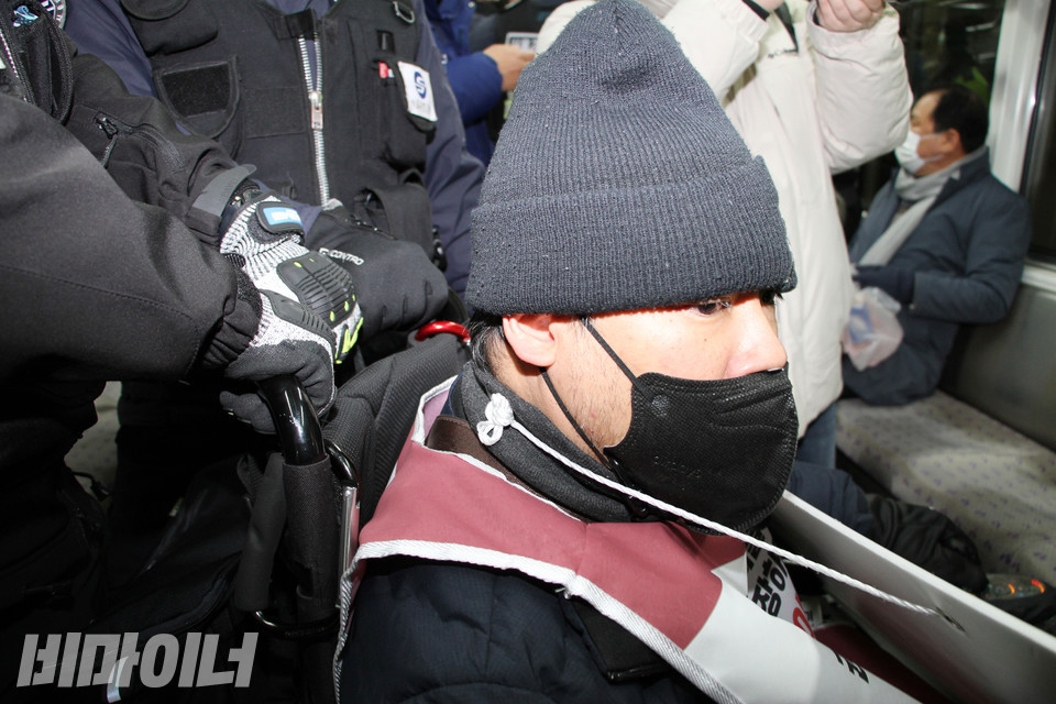 서울교통공사 지하철 보안관들이 장애인의 휠체어 뒷손잡이를 꽉 잡고 있다. 사진 강혜민