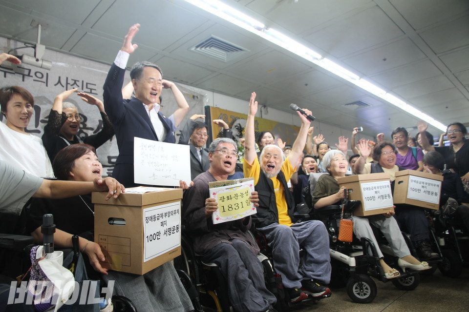 지난 2017년 8월 25일, 박능후 전 복지부 장관이 ‘장애등급제·부양의무제 폐지 농성장’에서 활동가들과 함께 환호하고 있다. 사진 비마이너DB