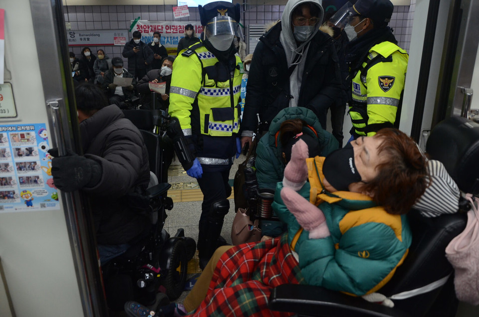 청암재단 폐쇄를 요구하는 장애인단체 활동가들이 지하철 출입문이 닫히지 못하도록 막고 시위를 하고 있다. 사진 뉴스민