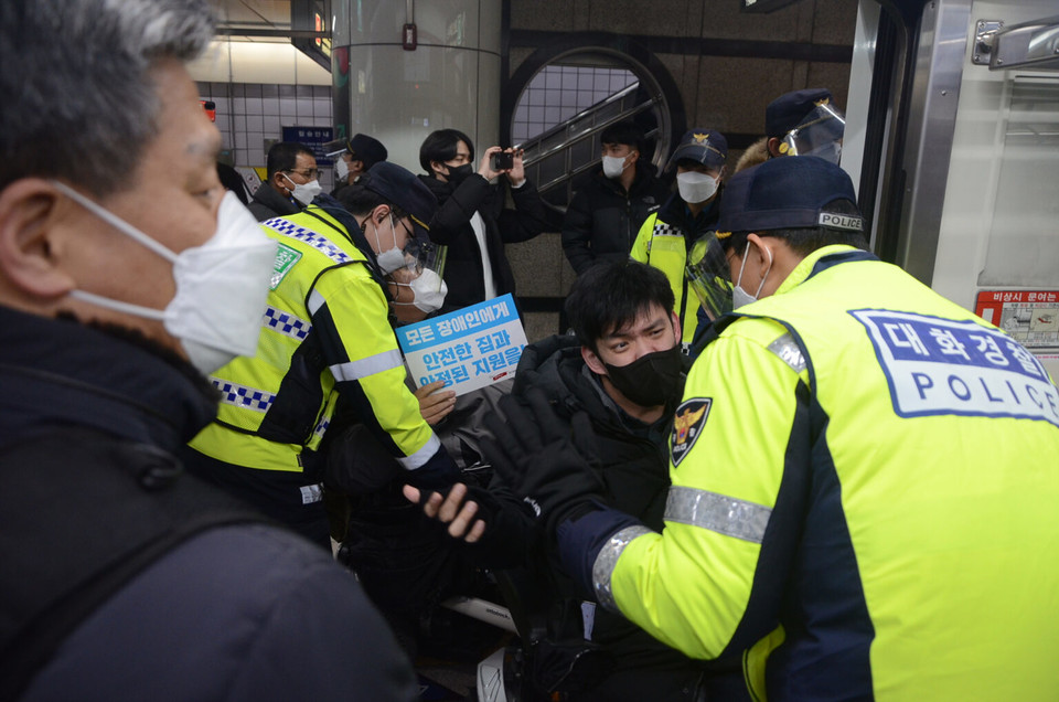 장애인 활동가들이 지하철을 점거하고 있다. 대화경찰이 활동가를 막아서고 있다. 사진 뉴스민