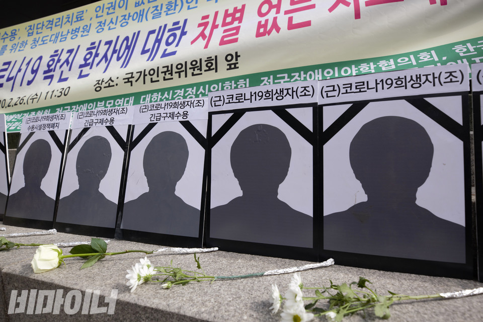 2020년 2월 26일, 장애계가 국가인권위원회에 시설 내 집단감염 문제에 대해 ‘시설의 폐쇄성’을 지적하며 긴급구제를 신청하는 기자회견을 열었다. 청도대남병원에서 코로나로 사망한 이들을 기리는 얼굴 없는 영정 앞에 국화가 놓여 있다. 사진 비마이너DB
