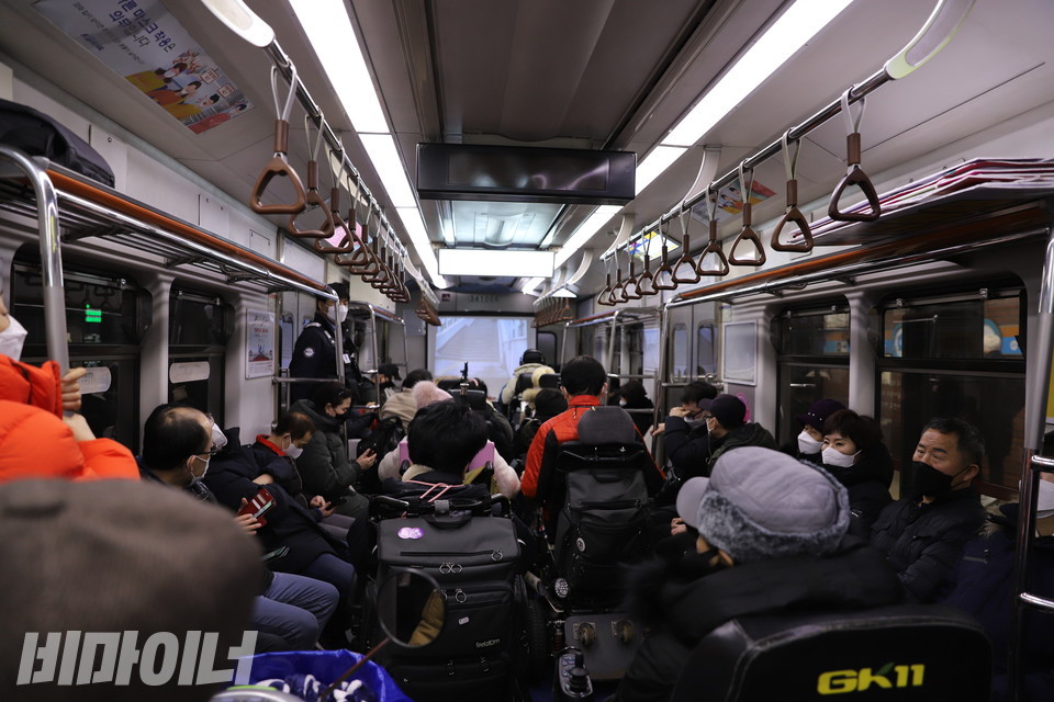 활동가들이 4호선 오이도역행 열차 1호차에서 영화 ‘버스를 타자!’를 감상하고 있다. 사진 하민지