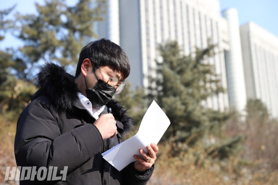 김경태 씨가 기자회견 도중 발언하며 울고 있다. 안경에 김이 서렸다. 김 씨 뒤로 법원 건물이 보인다. 사진 하민지