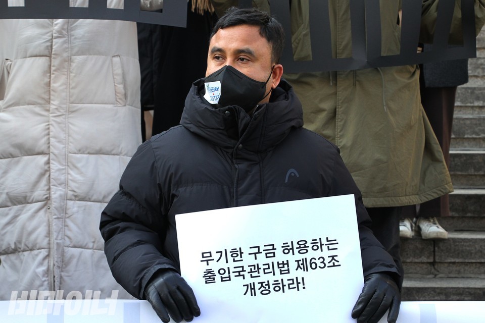 섹알마문 이주노동자노동조합 활동가가 ‘무기한 구금 허용하는 출입국관리법 제63조 개정하라!’라고 적힌 피켓을 들고 있다. 사진 하민지