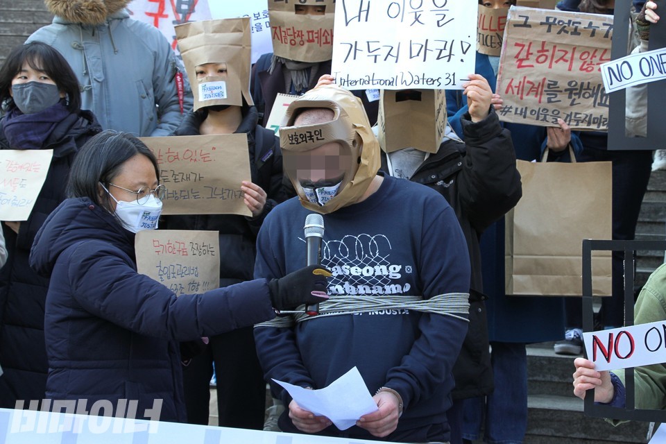 M 씨가 화성외국인보호소에서 겪은 고문상태를 재현한 채 기자회견에서 발언하고 있다. 사진 하민지