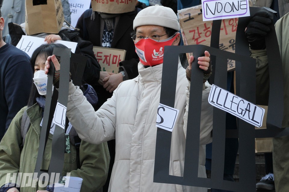 활동가가 검은색 쇠창살 피켓을 찢어 외국인보호소 폐지를 표현하고 있다. 사진 하민지