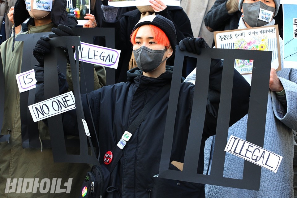 활동가가 검은색 쇠창살 피켓을 찢어 외국인보호소 폐지를 표현하고 있다. 사진 하민지