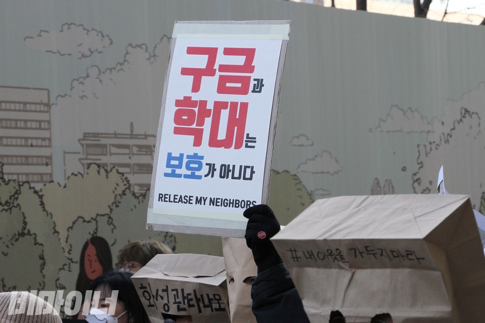 한 활동가가 “구금과 학대는 보호가 아니다. 내 이웃을 풀어줘라(Release my neighbors)”라고 적힌 피켓을 높이 들고 있다. 사진 하민지