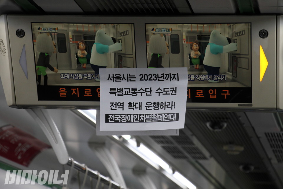 지하철 2호선 전광판에 '서울시는 2023년까지 특별교통수단 수도권 전역 확대 운행하라'라는 피켓이 붙어 있다. 사진 허현덕 
