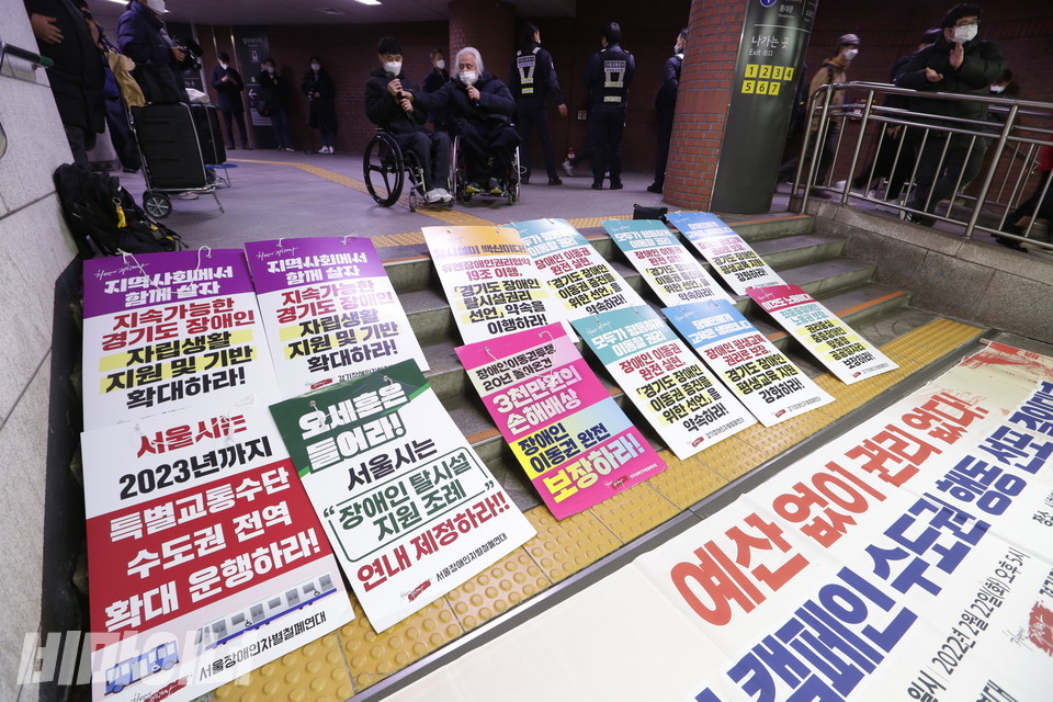 바닥에 놓인 현수막에는 “예산 없이 권리 없다!”는 문구가 쓰여 있으며 계단에는 장애인권리예산과 관련한 각종 요구안이 적힌 피켓이 있다. 사진 강혜민