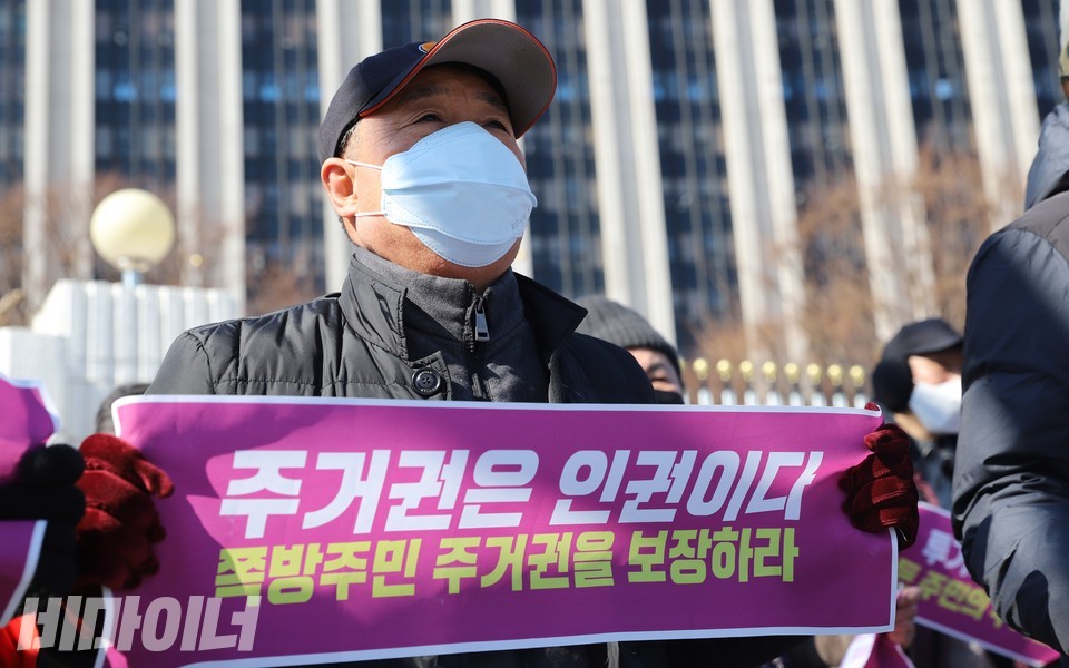 백광헌 동자동공공주택주민모임 부위원장이 ‘주거권은 인권이다. 쪽방주민 주거권을 보장하라’라고 적힌 작은 현수막을 펼쳐 보이고 있다. 사진 하민지