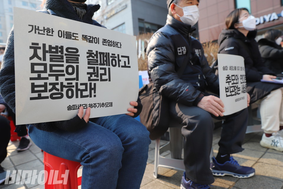 추모제 참가자가 '가난한 이들도 똑같이 존엄하다. 차별을 철폐하고 모두의 권리를 보장하라!'라고 적힌 피켓을 들고 있다. 사진 허현덕