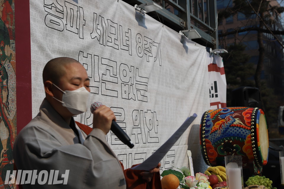 서연 스님이 '송파 세 모녀 8주기, 빈곤없는 세상을 원하는 우리의 입장'을 낭독하고 있다. 뒤로는 추모제를 알리는 현수막이 걸려 있다. 현수막에는 지난여름 코로나19 위기 속에서 세상을 떠난 이들을 추모하는 메시지가 적혀 있다. 사진 허현덕